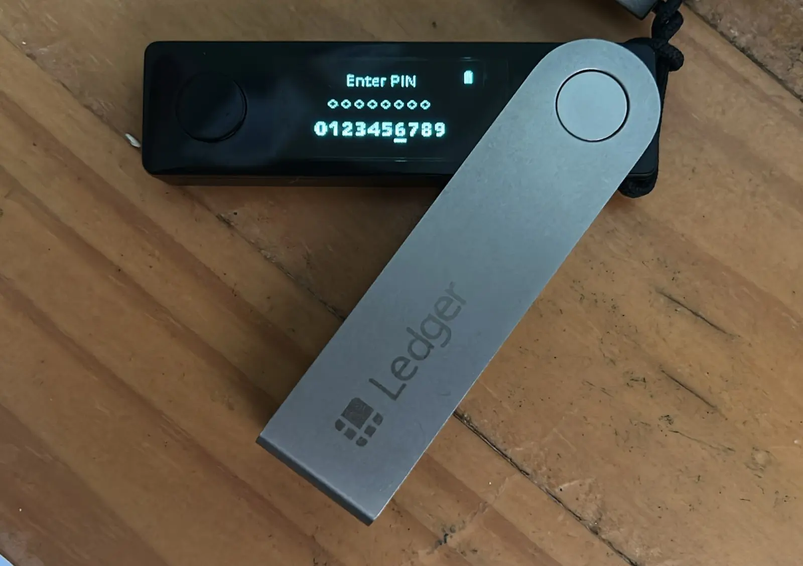 A Ledger hardware wallet device displaying a PIN entry screen.